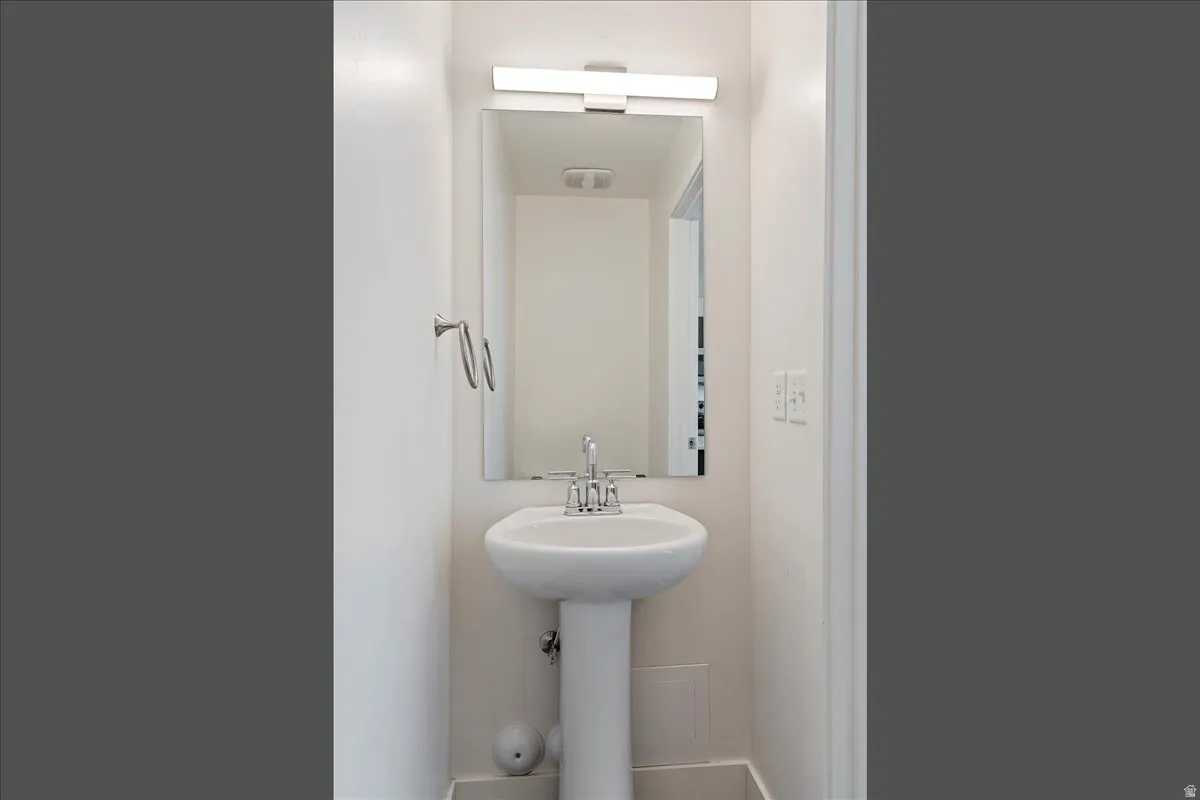 Pedestal sink with chrome-finish faucet and towel ring