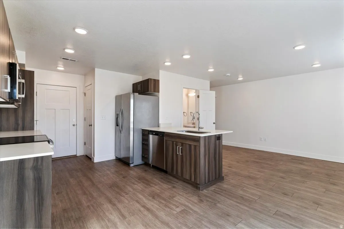 Open-concept kitchen and living area featuring wood-finish flooring throughout