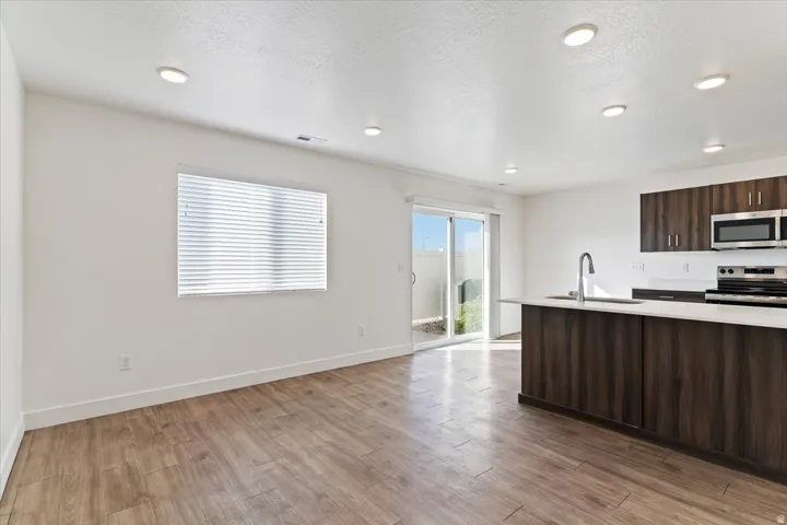 Open-concept living space featuring wood-finish flooring and recessed lighting