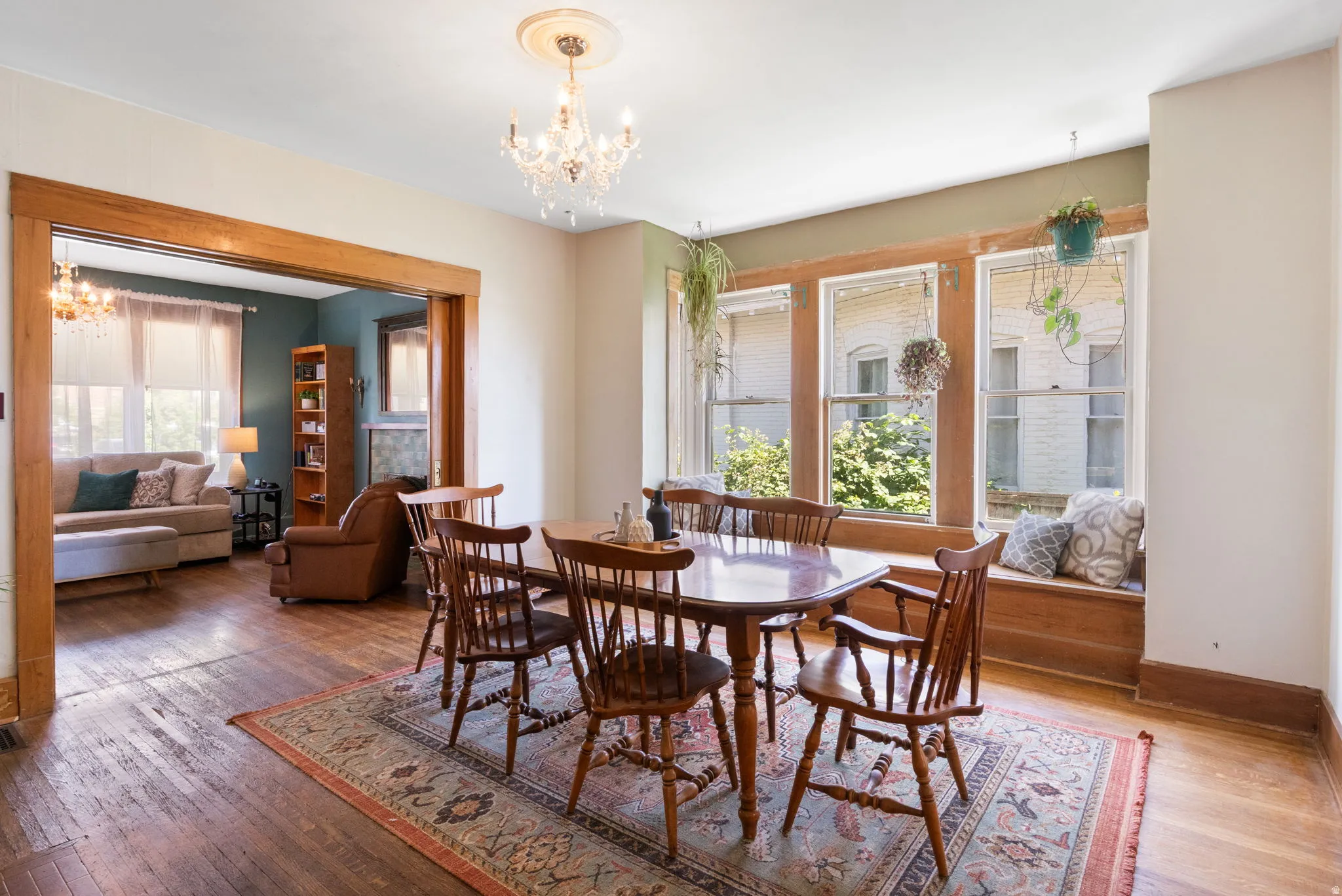 Dining area featuring wood-finish flooring, a crystal chandelier, and a built-in window seat