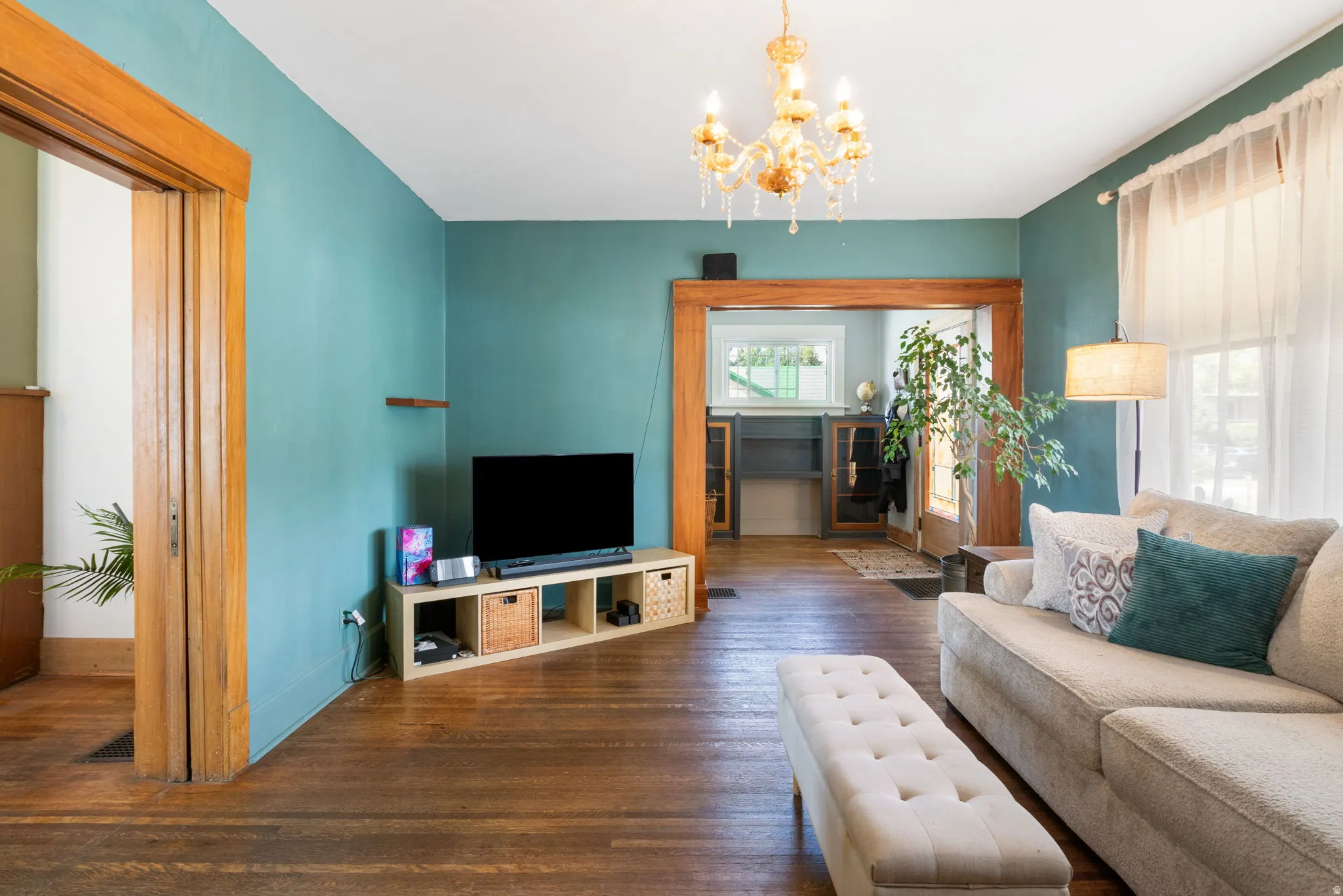 Living area featuring wood-finish flooring and a decorative chandelier