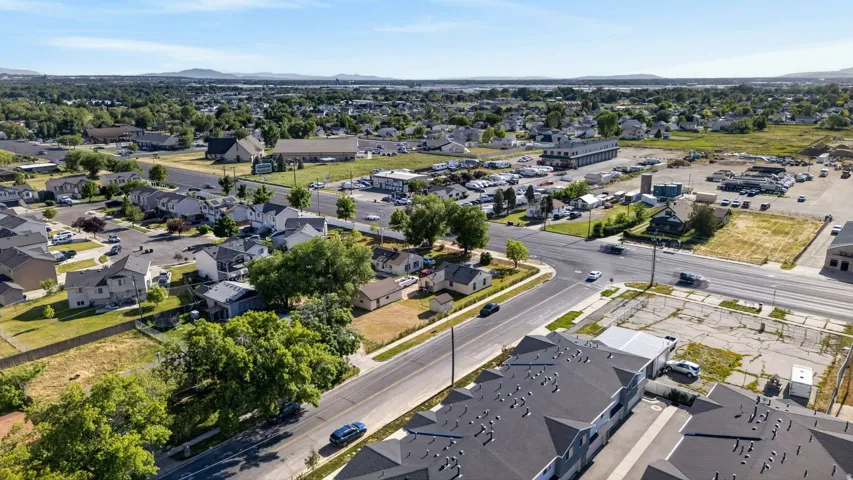 Residential area featuring single-family homes and multi-story townhouse-style properties, mature trees, and paved streets