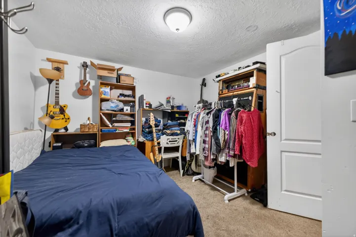 Carpeted room featuring white walls and a ceiling-mounted light fixture