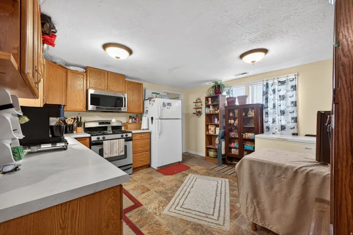 Kitchen featuring wood cabinetry, stainless steel oven with gas range, and a built-in stainless steel microwave