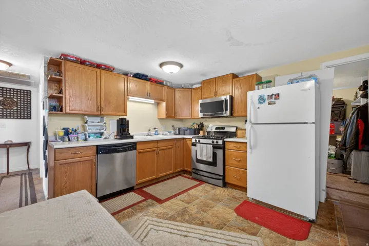 Kitchen featuring wood-finish cabinetry, laminate countertops, and tile flooring
