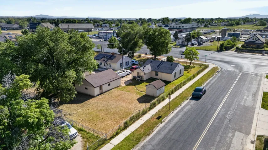 Expansive corner lot featuring a main residence, detached garage, and an additional shed