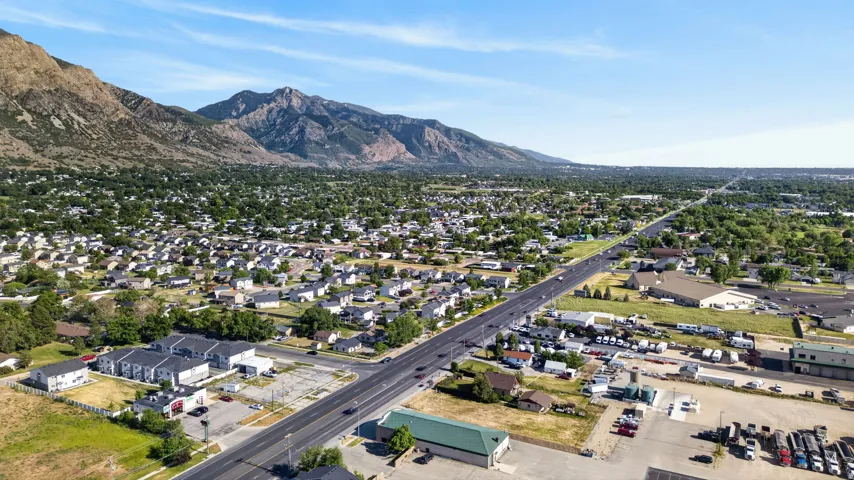 Expansive landscape featuring distant mountains, a wide highway, and a suburban residential area with numerous houses