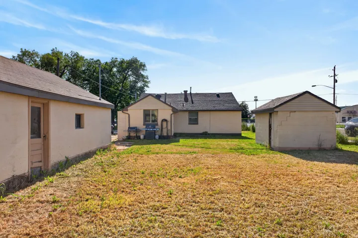 Expansive rear yard featuring a detached garage, additional storage shed, and direct access to the main residence
