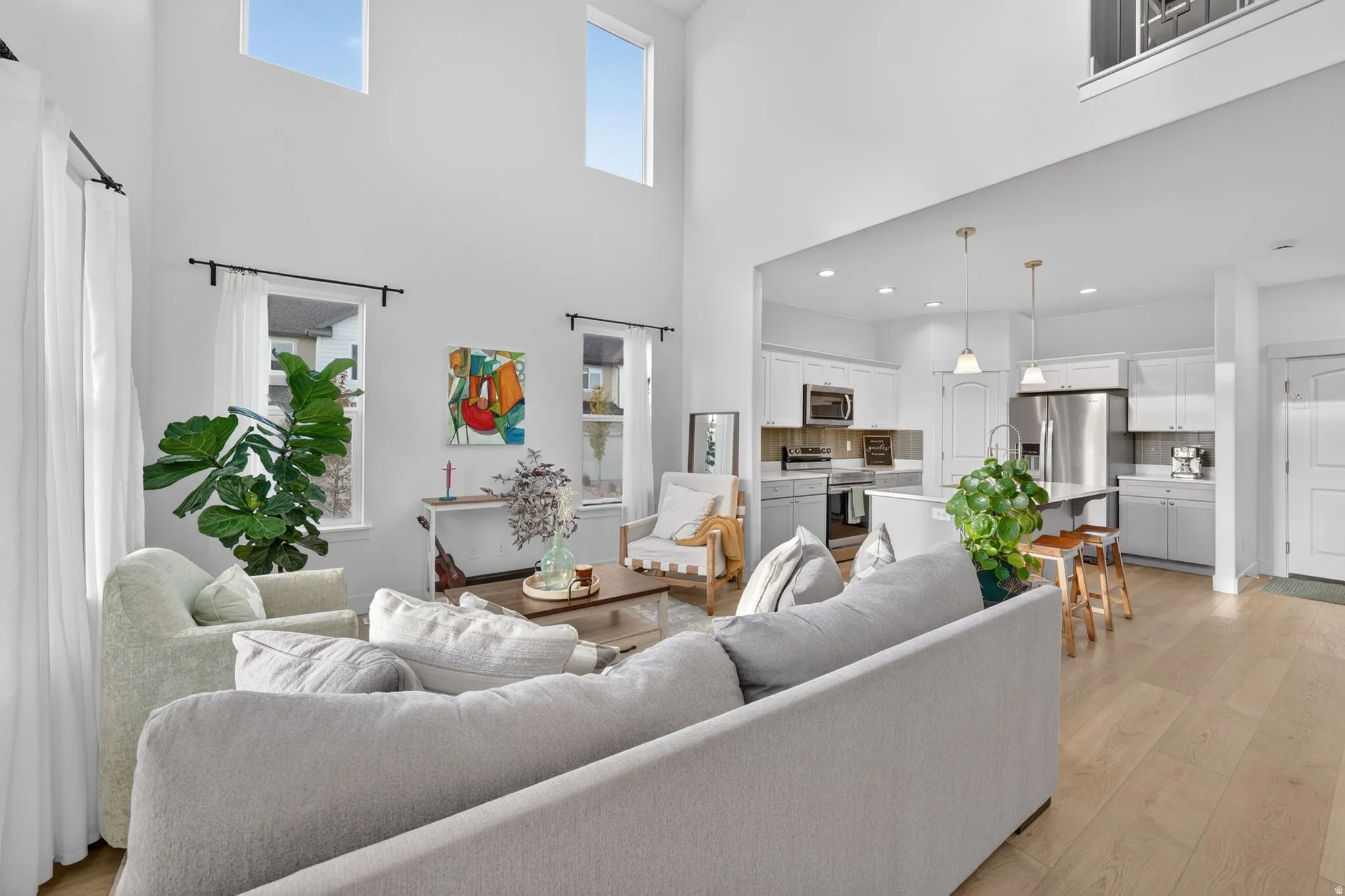 Spacious living area featuring high ceilings and multiple windows