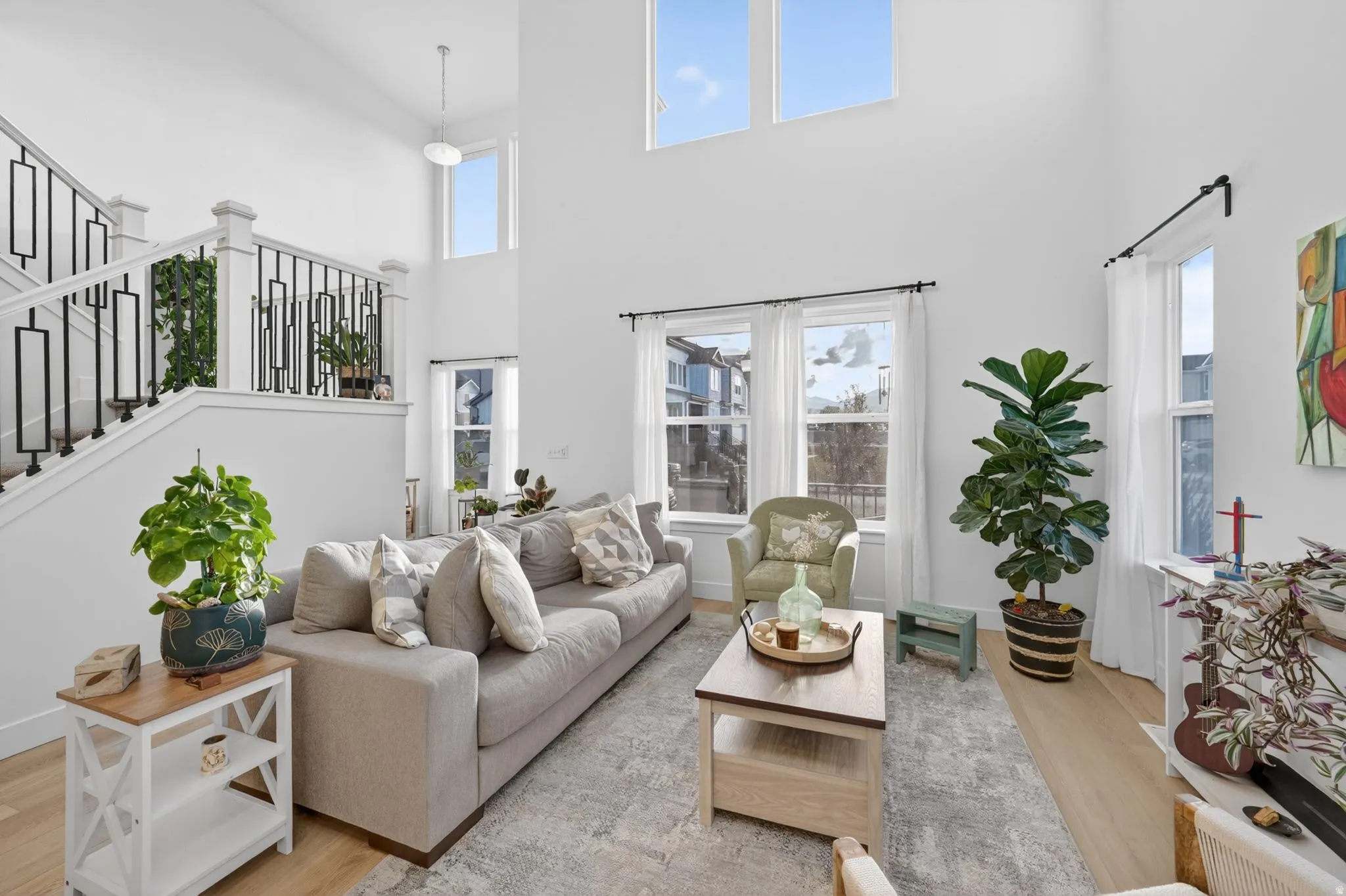 Two-story living area featuring a prominent staircase with decorative black metal railings