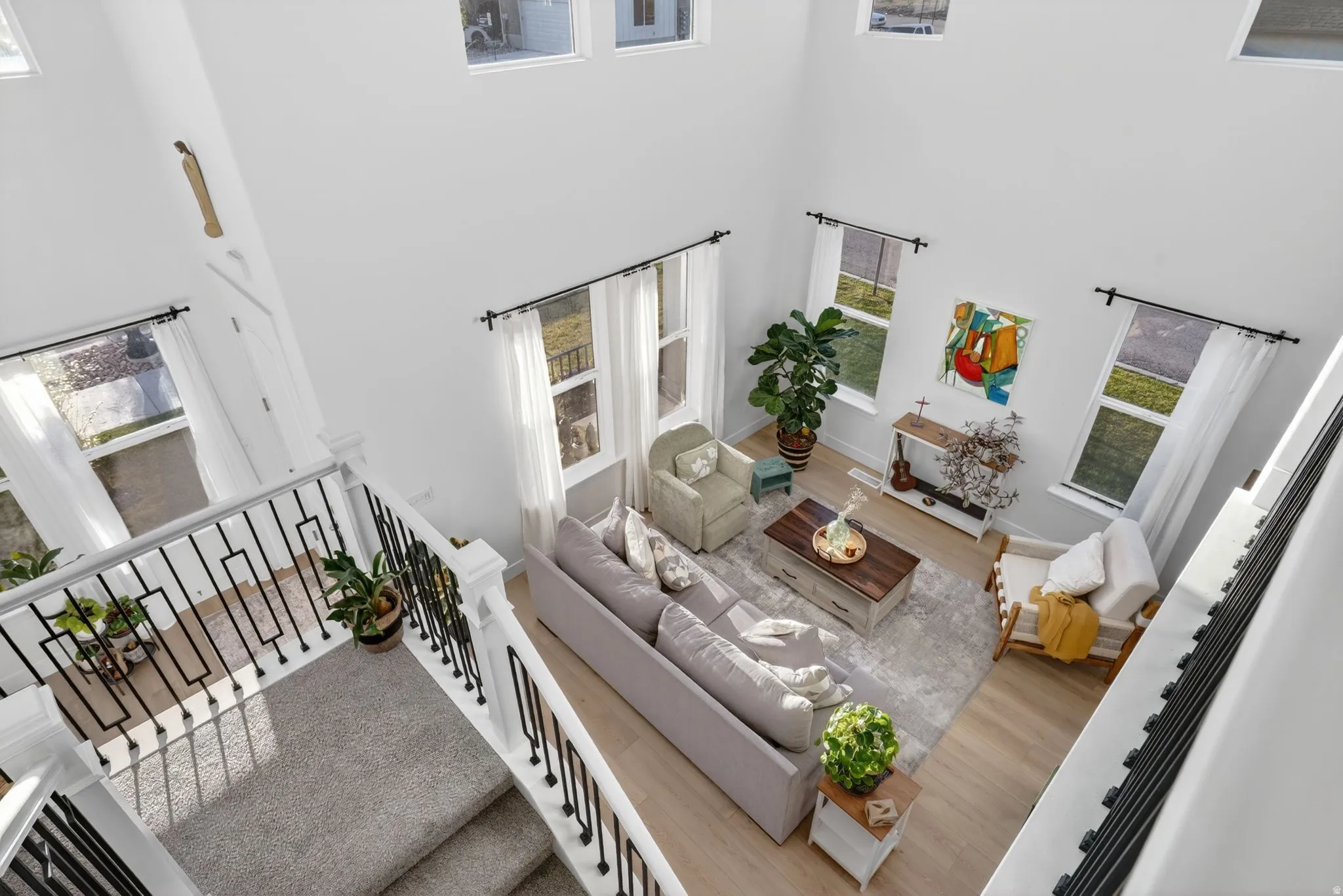 Two-story living area featuring tall ceilings and abundant natural light from multiple windows