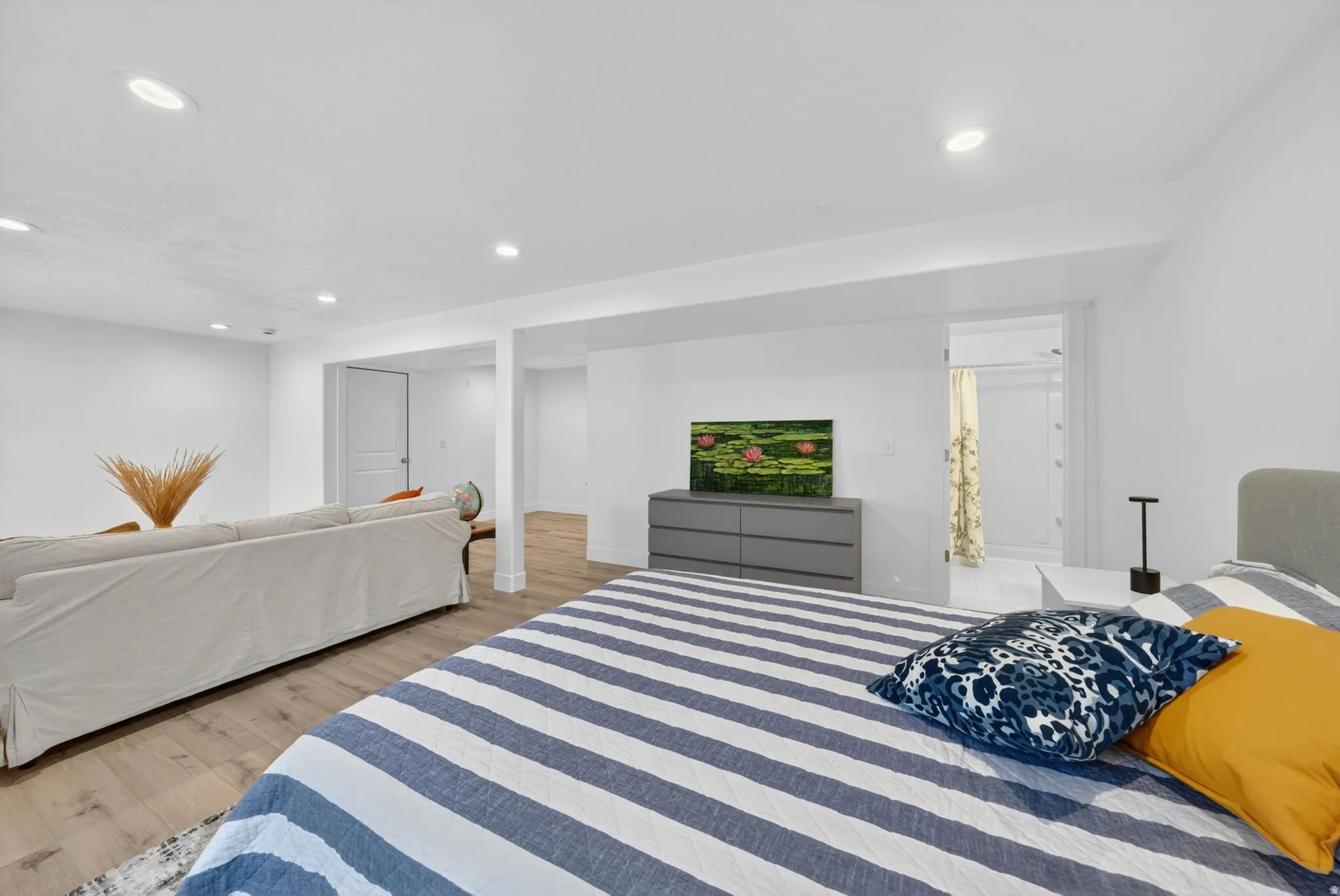Open-concept space featuring light wood-finish flooring, recessed lighting, and white painted walls