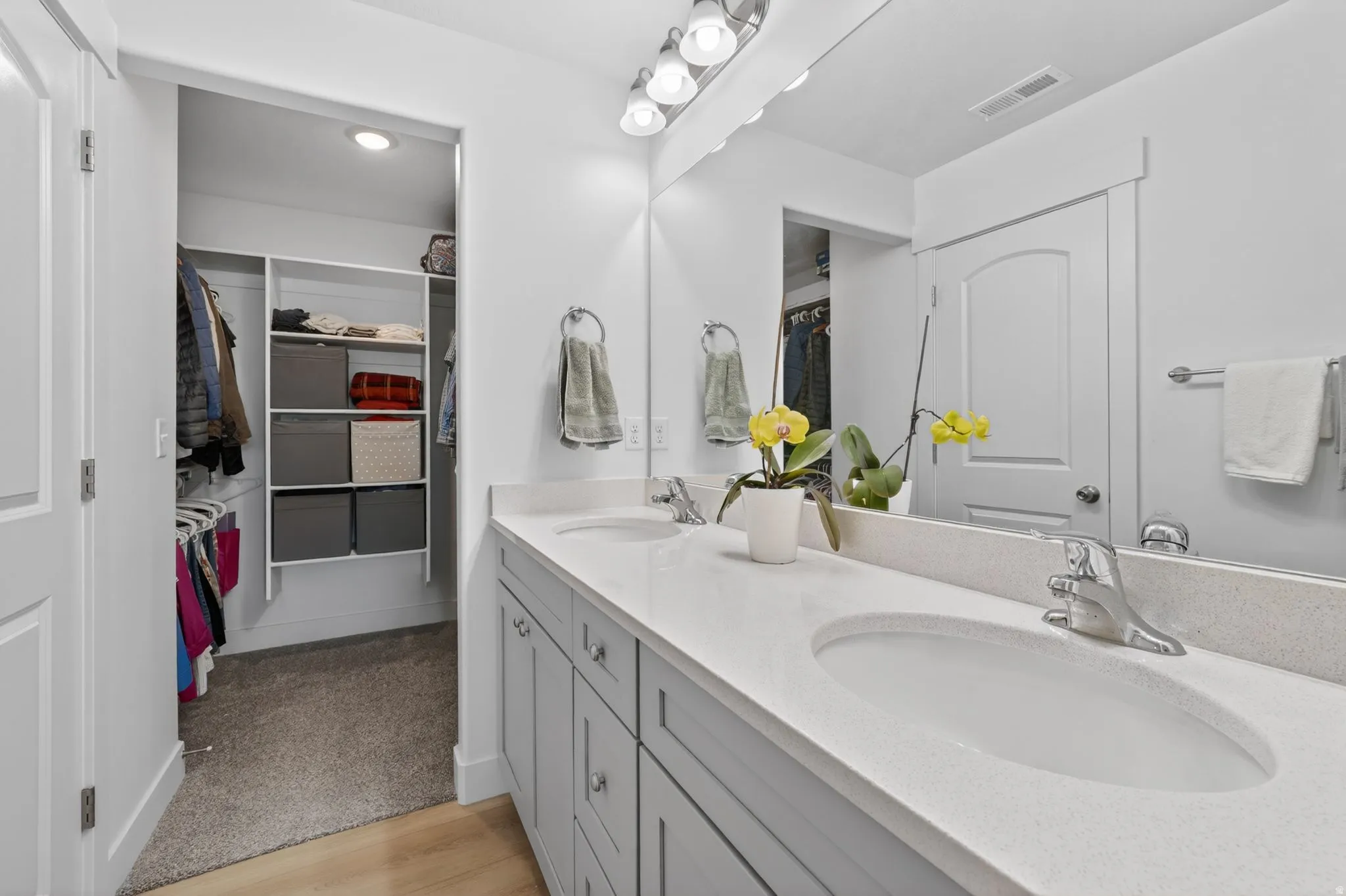 Bathroom vanity featuring dual undermount sinks, stone-finish countertop, and chrome fixtures