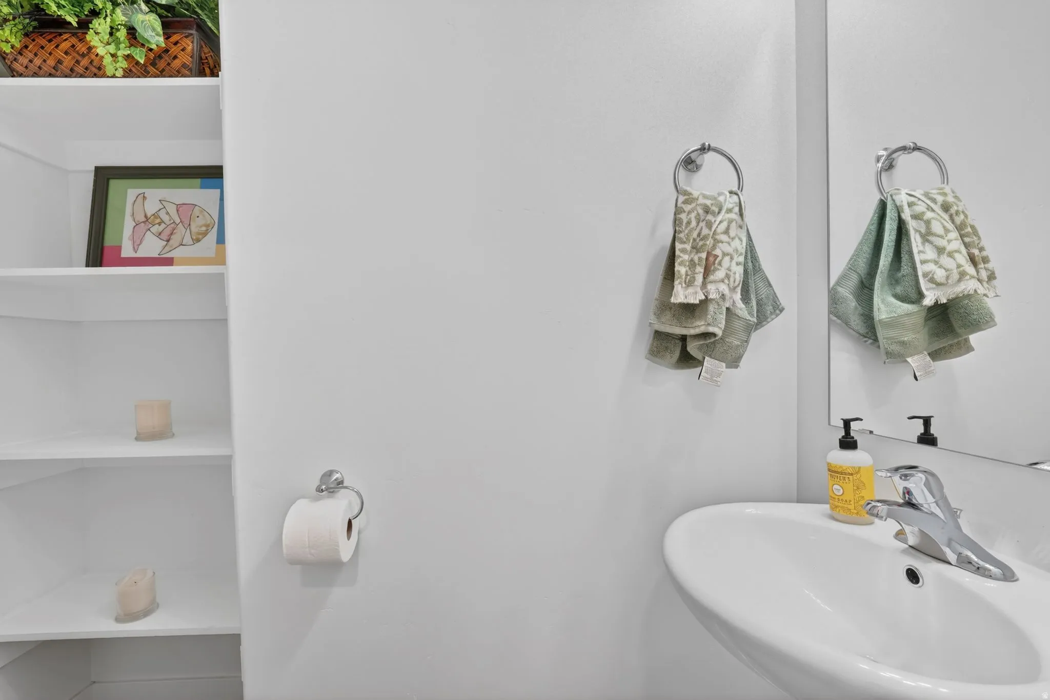 White wall-mounted sink with chrome faucet and mirror
