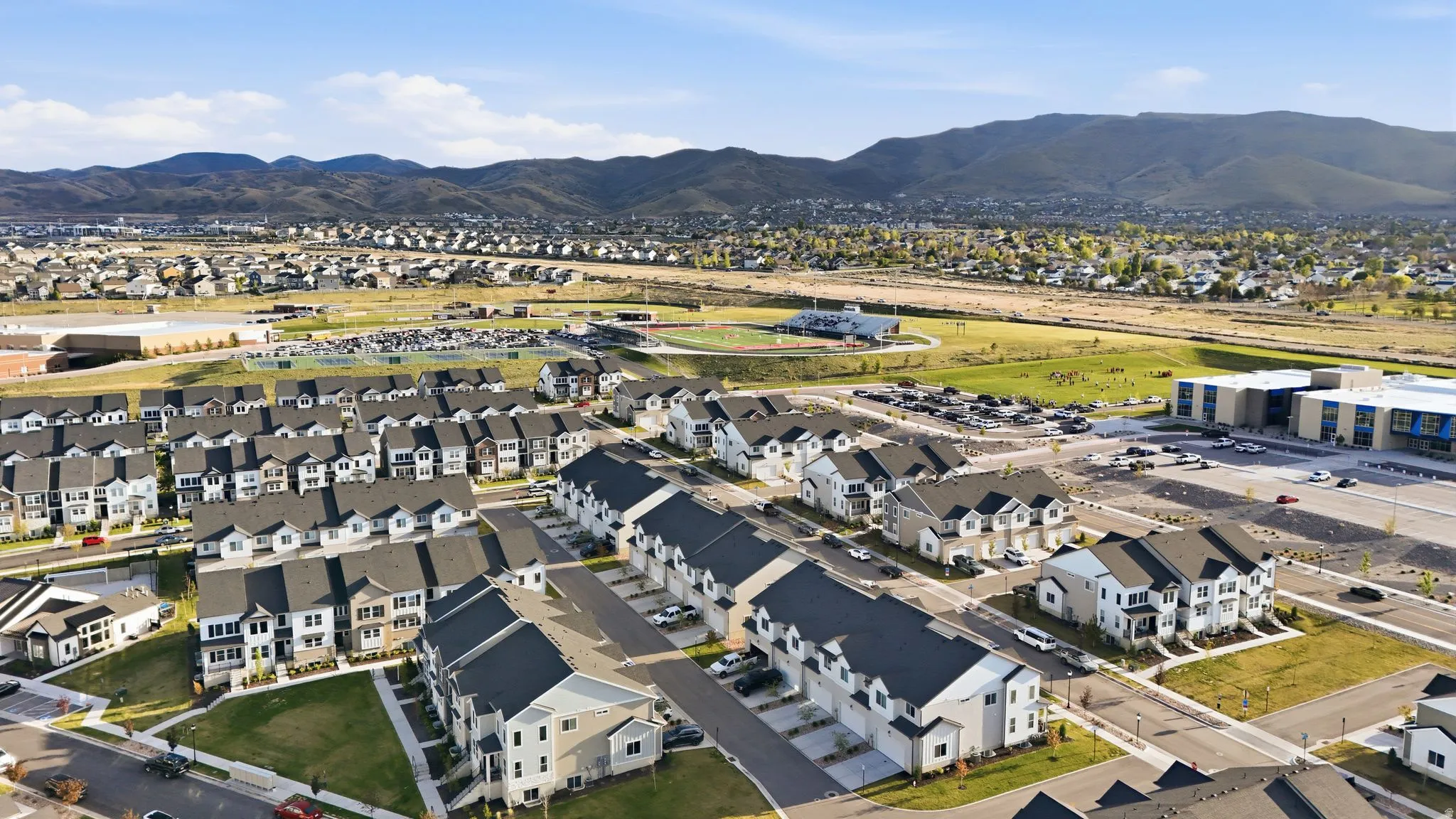 Newer construction townhome community featuring varied architectural styles and dark shingle roofing