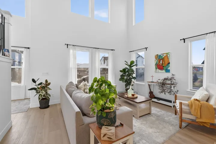 Spacious living area featuring double-height ceilings and a light wood-finish flooring