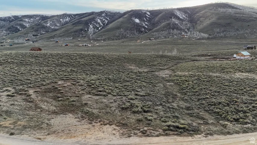 Expansive land parcel featuring natural shrubbery and distant mountain scenery