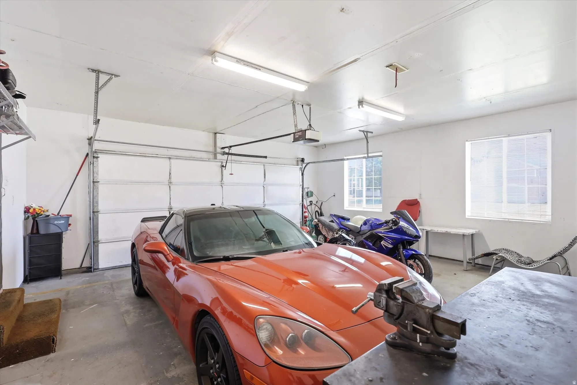 Spacious garage featuring a concrete floor, overhead lighting, and white walls