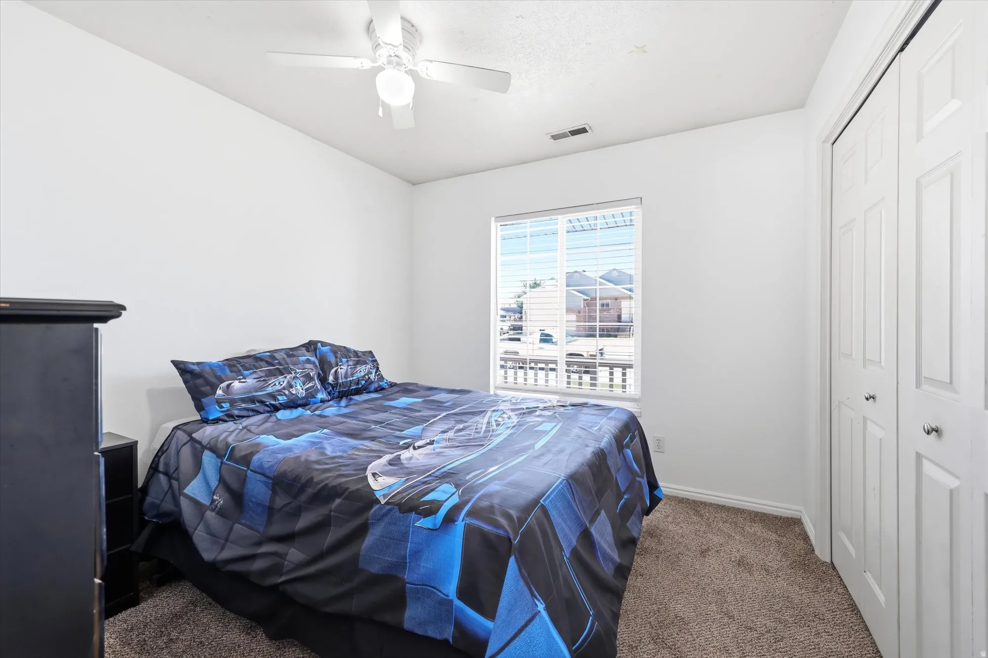 Bedroom featuring a ceiling fan with light fixture, neutral carpet, and a window with blinds