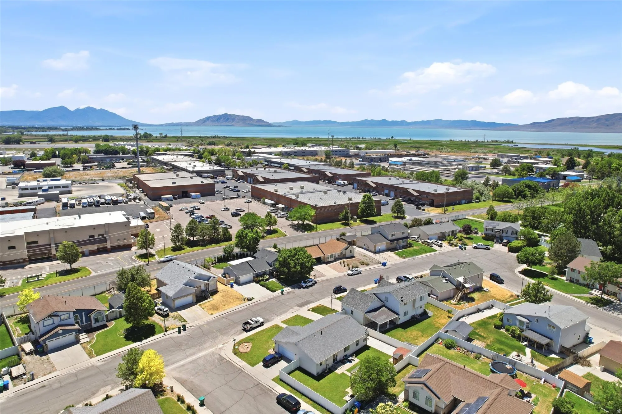 Aerial perspective showcasing a residential neighborhood with a large body of water and distant mountains