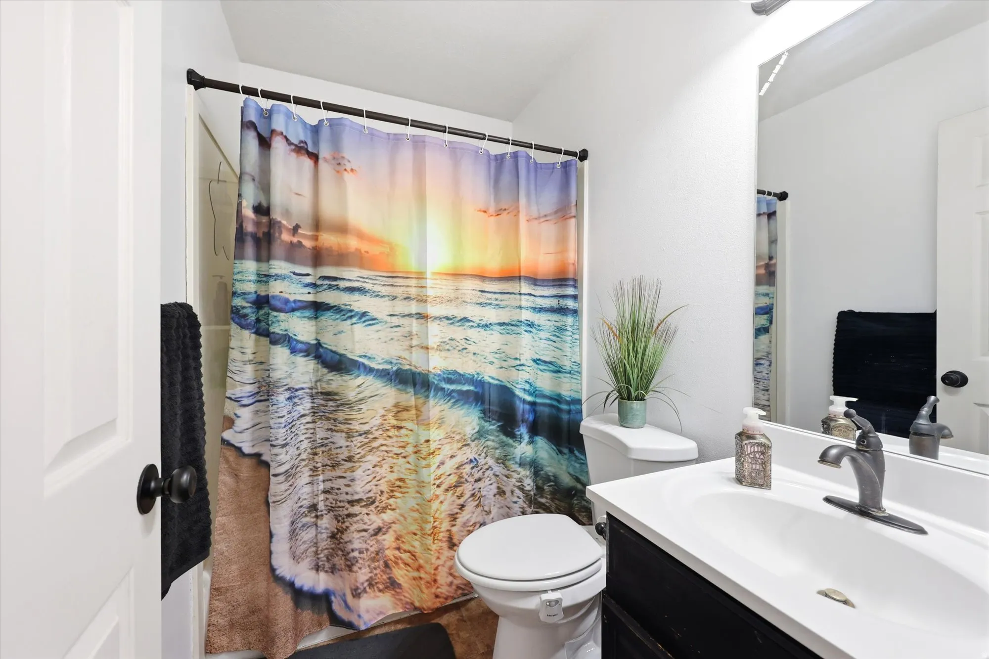 Full bathroom featuring a shower-tub combination, a toilet, a vanity with an integrated sink, and an overhead light fixture