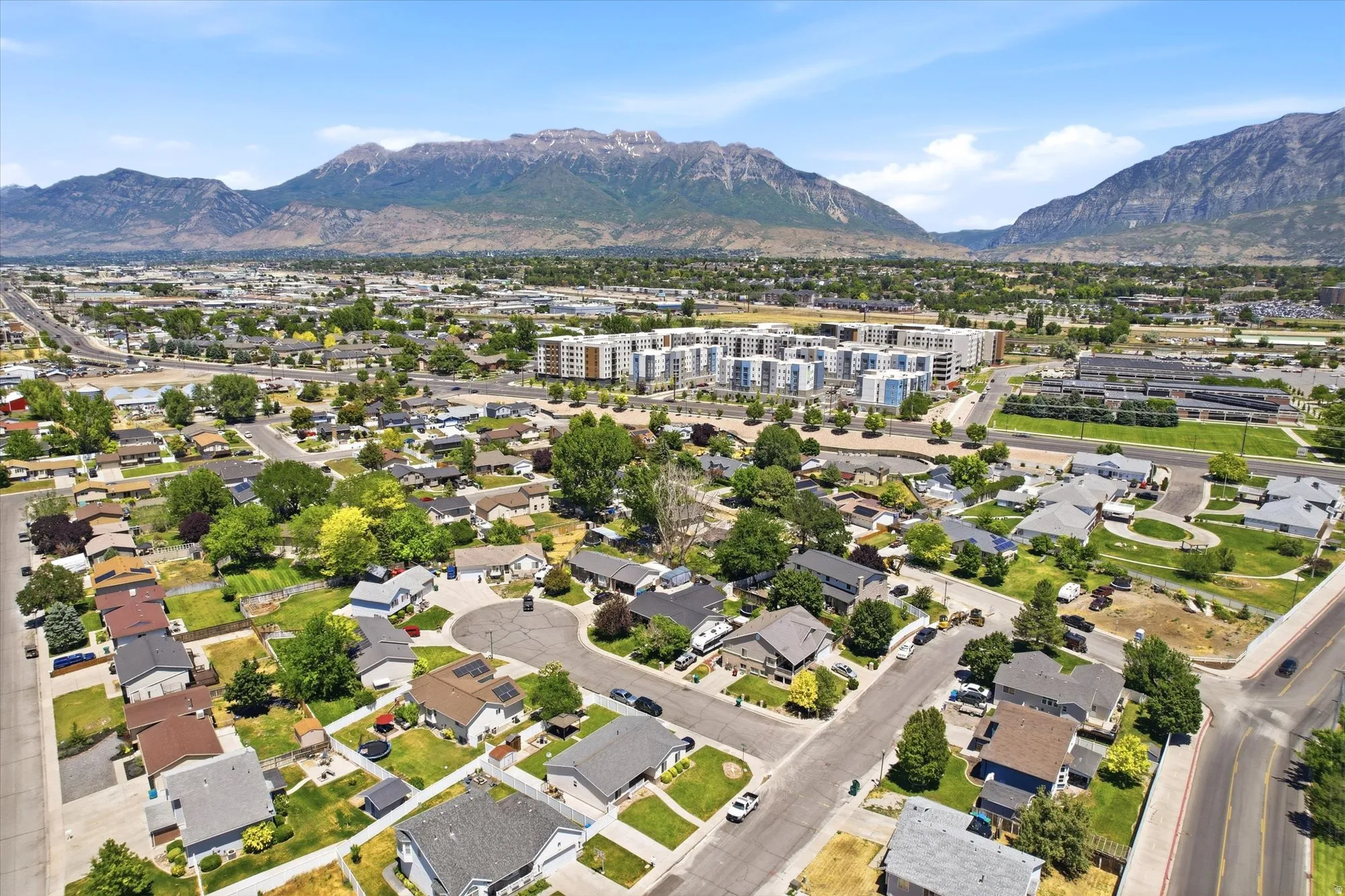 Residential neighborhood with mature trees, established streets, and mountain backdrop