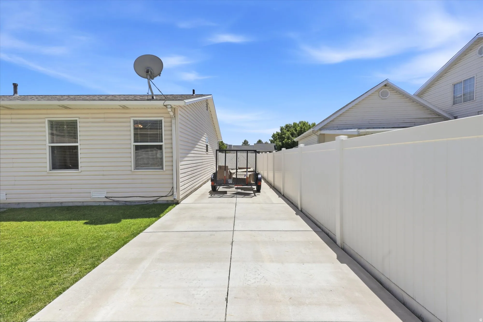 Concrete driveway with a vinyl privacy fence