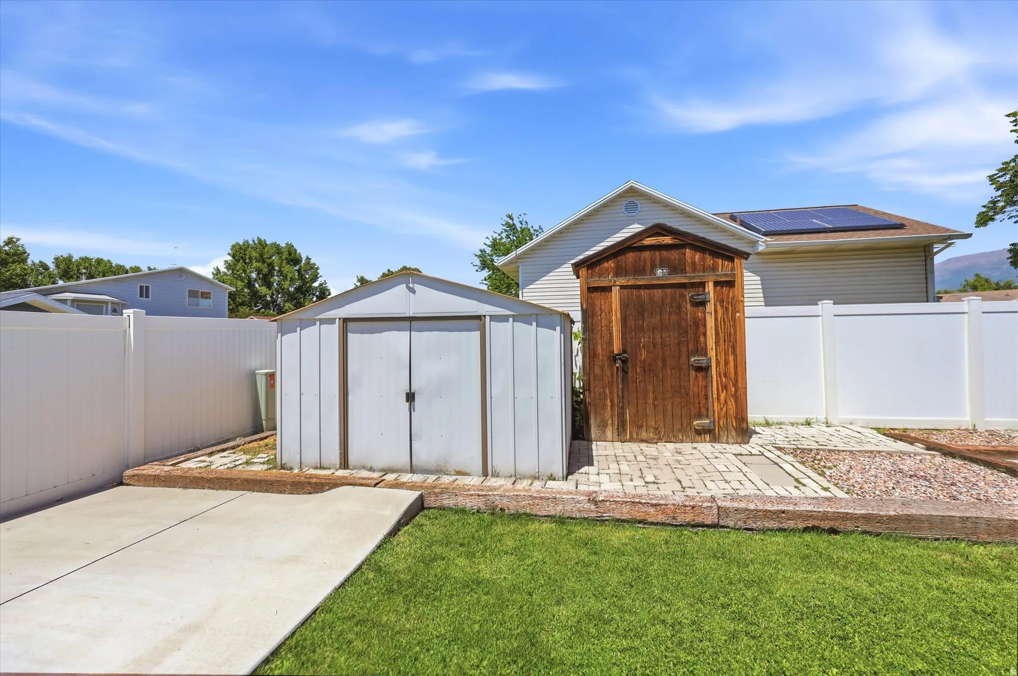 Backyard featuring a vinyl privacy fence, concrete patio, and a grass lawn