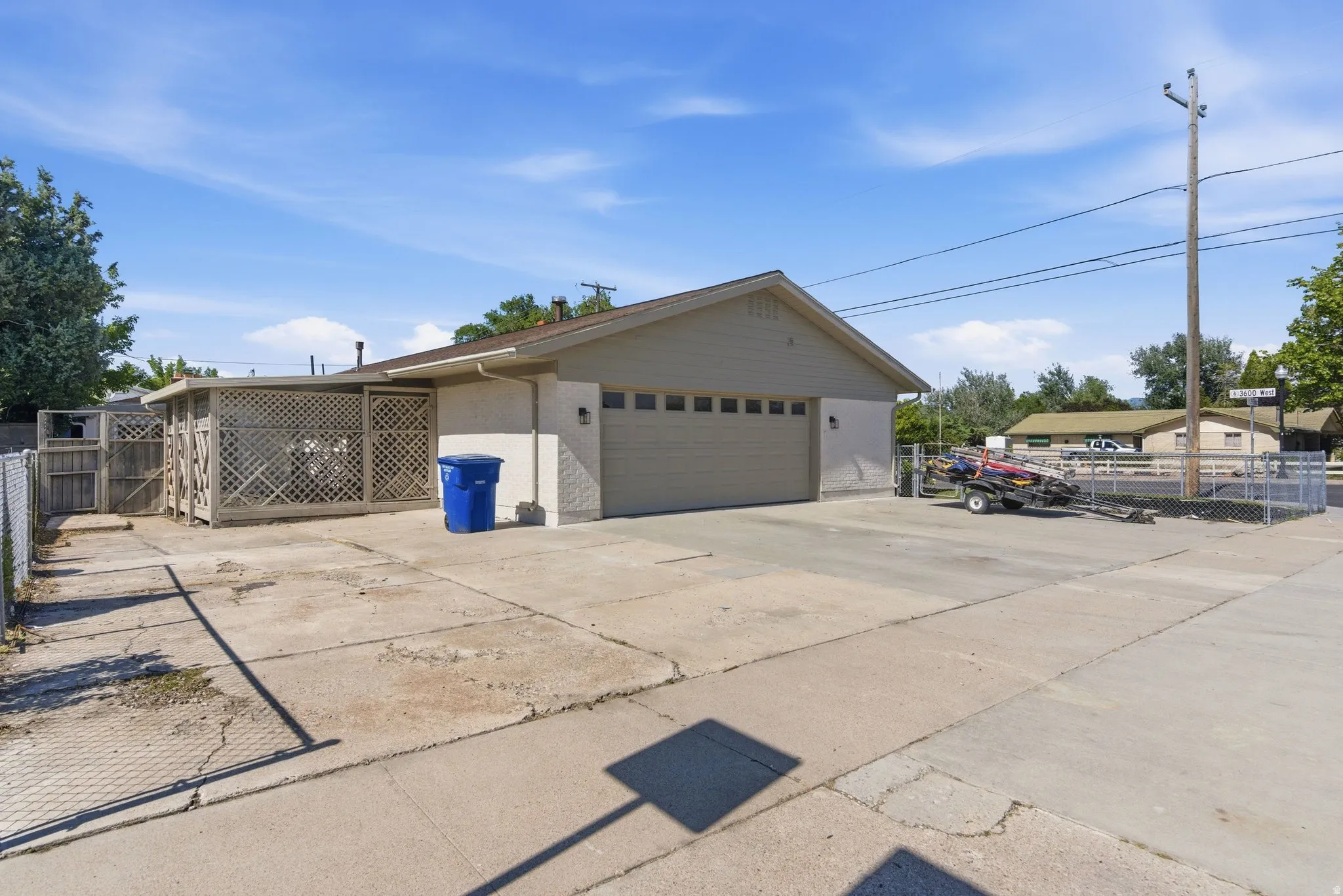 Expansive concrete driveway and two-car garage with a panel door
