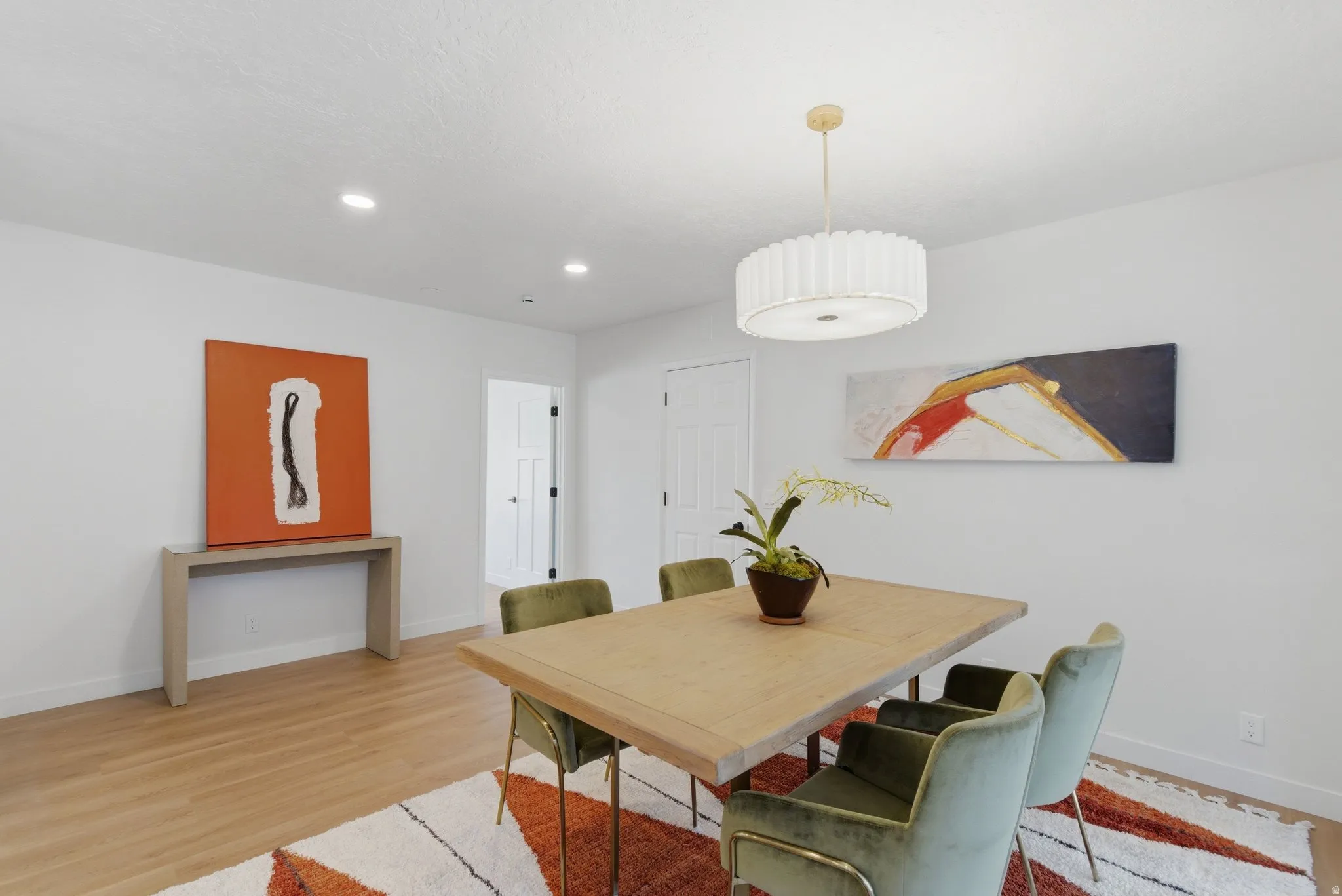 Dining area featuring wood-finish flooring, recessed lighting, and a contemporary drum pendant light fixture