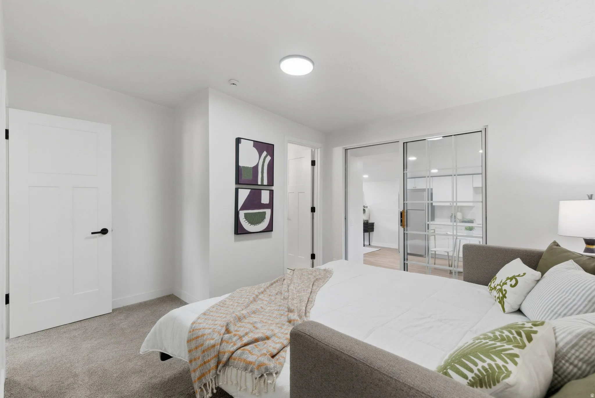 Versatile room with plush carpeting, offering a bright ambiance with white walls and a ceiling-mounted light fixture