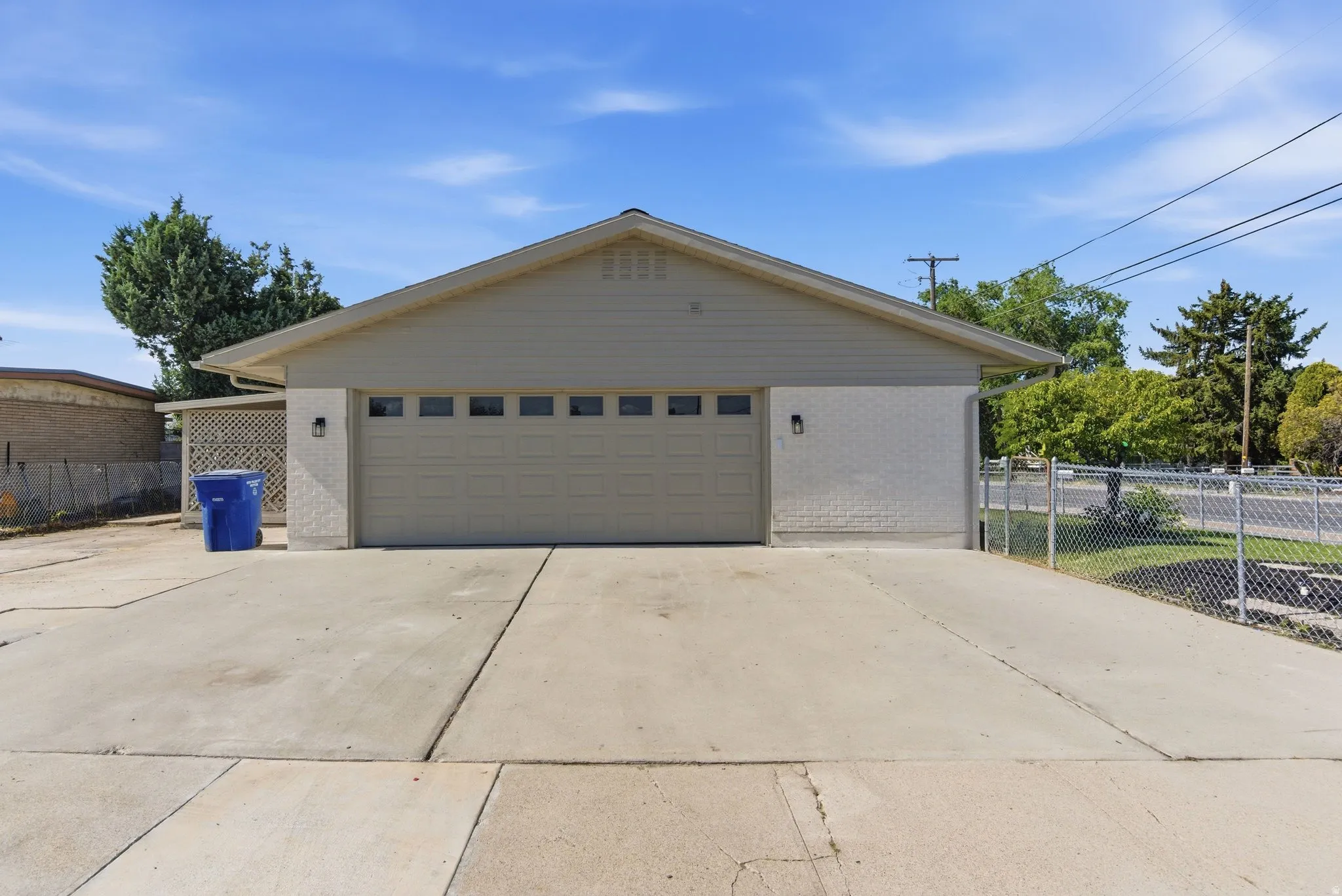 Attached two-car garage featuring panel door with transom windows