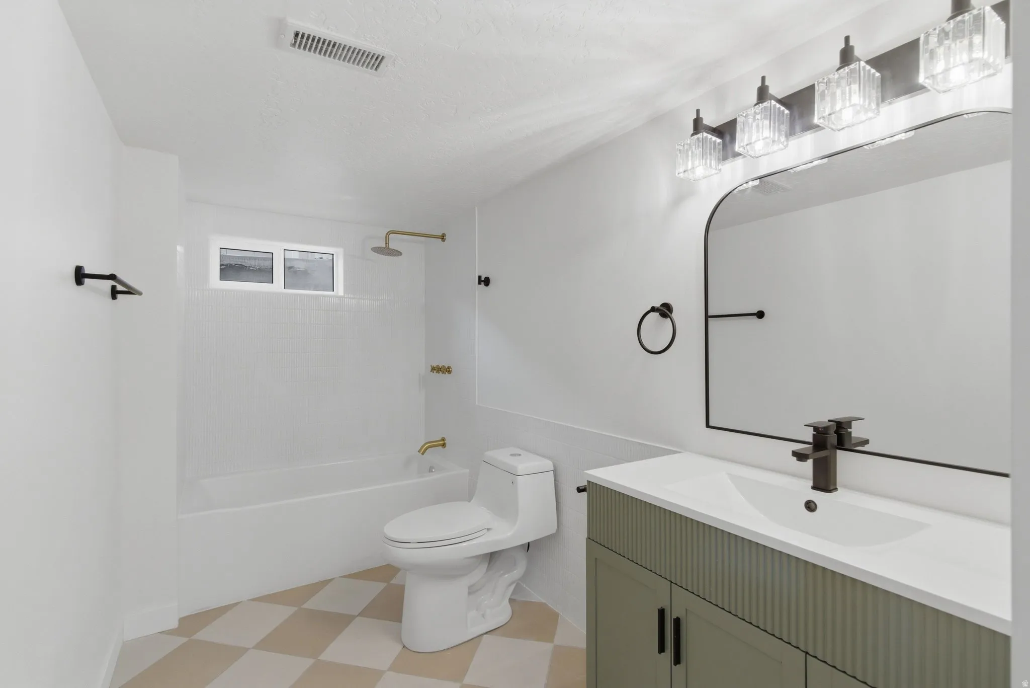 Bathroom featuring a white bathtub with gold-tone fixtures, a toilet, and a vanity with a fluted sage green cabinet