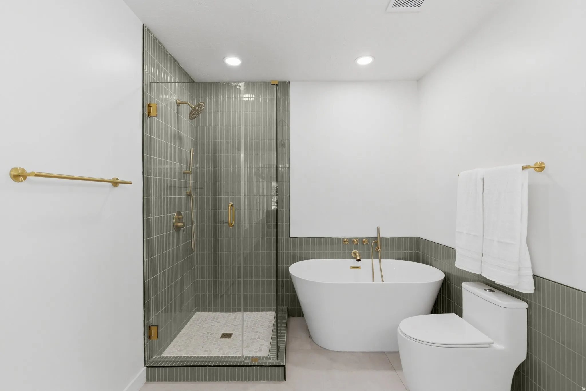 Contemporary bathroom featuring a frameless glass shower enclosure and a freestanding soaking tub