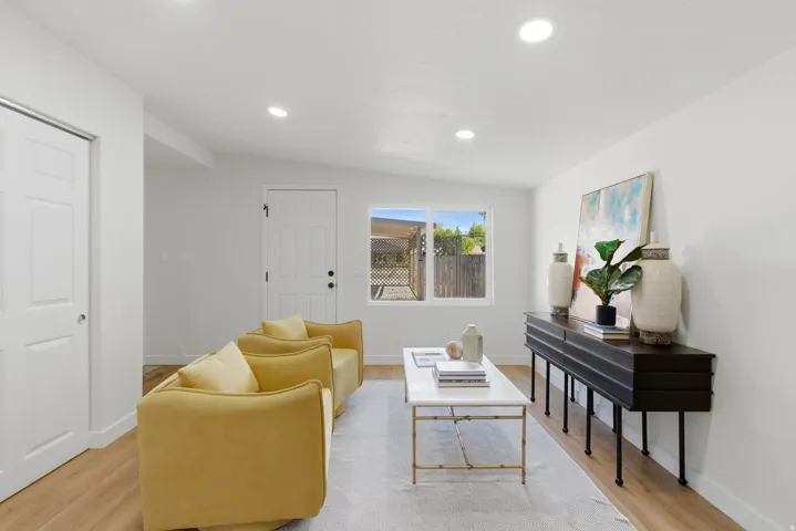 Bright interior space featuring recessed lighting, wood-finish flooring, white walls, and a large window overlooking the exterior