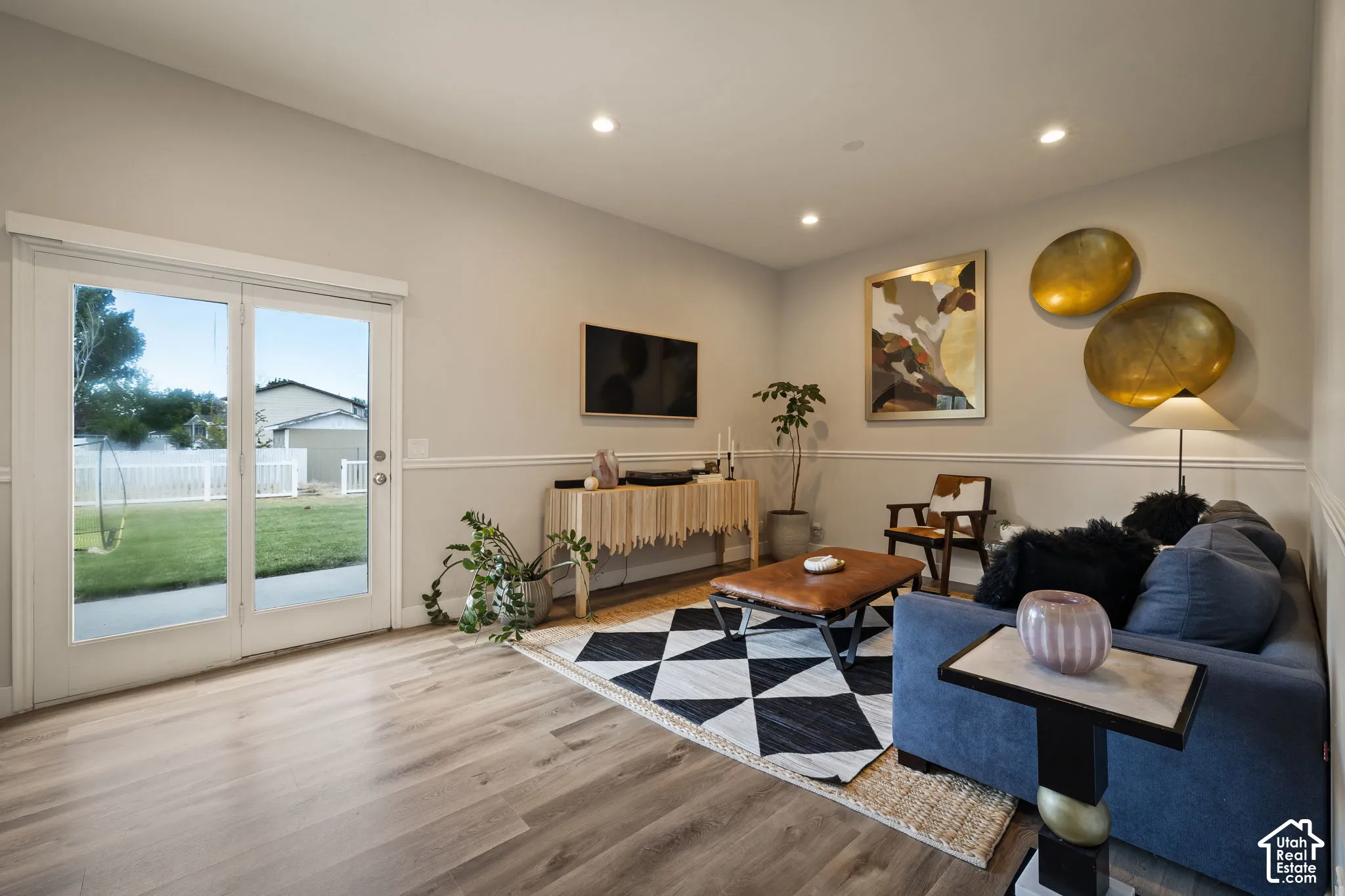 Spacious living area featuring wood-finish flooring, recessed lighting, and a chair rail molding