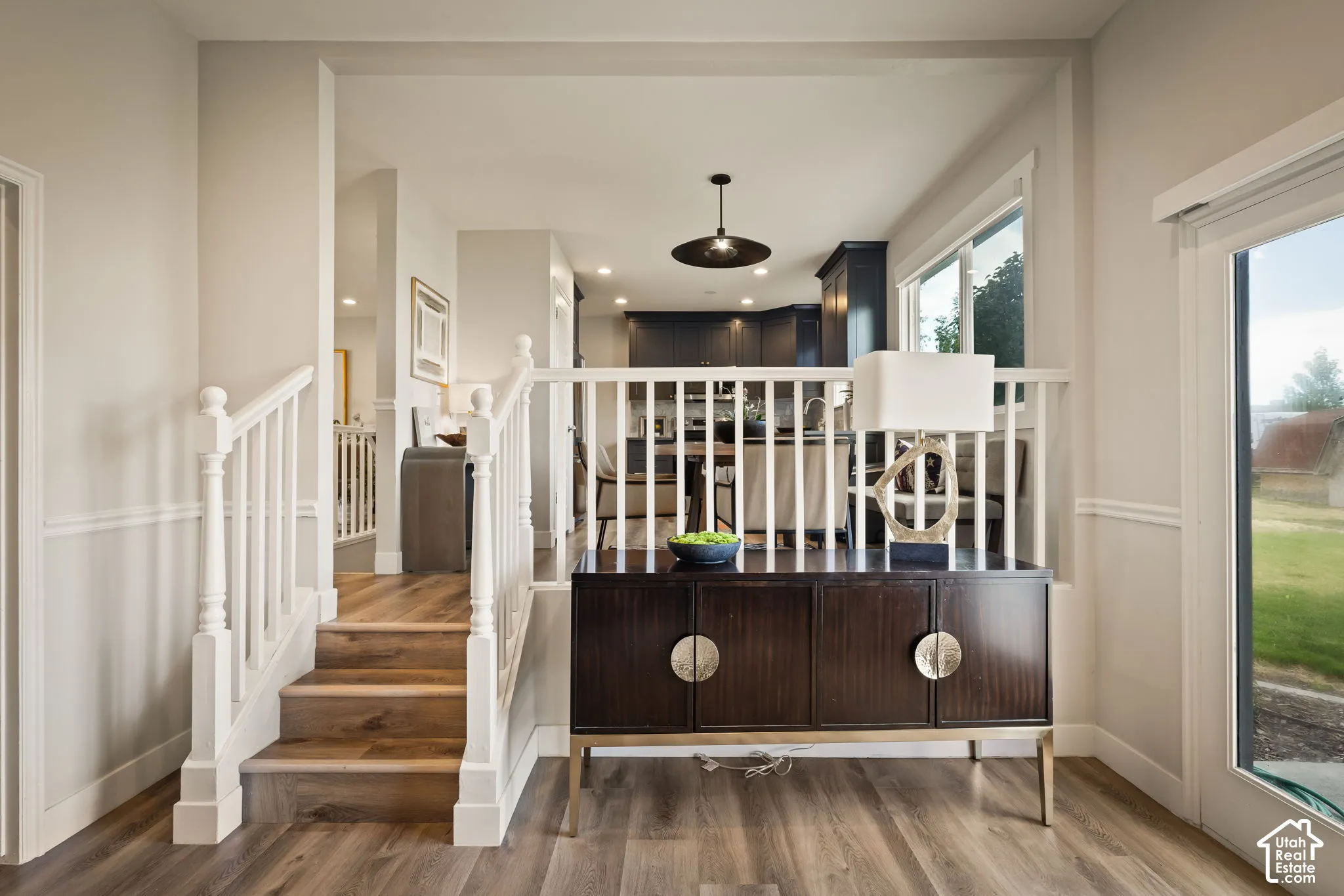Split-level entry featuring wood-finish flooring, white spindle railings, and chair rail molding
