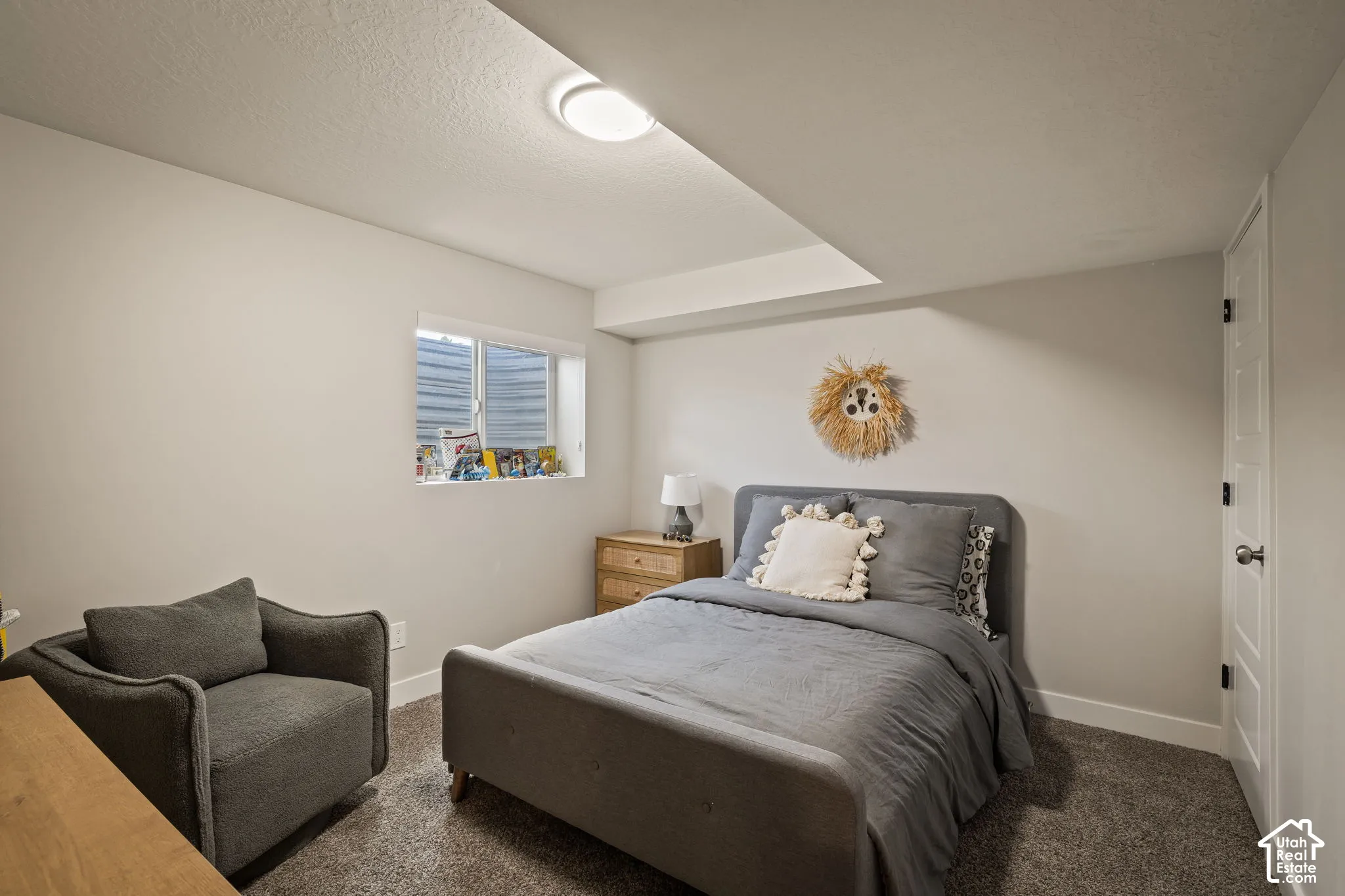 Carpeted room featuring a single window, white trim, and a ceiling light fixture