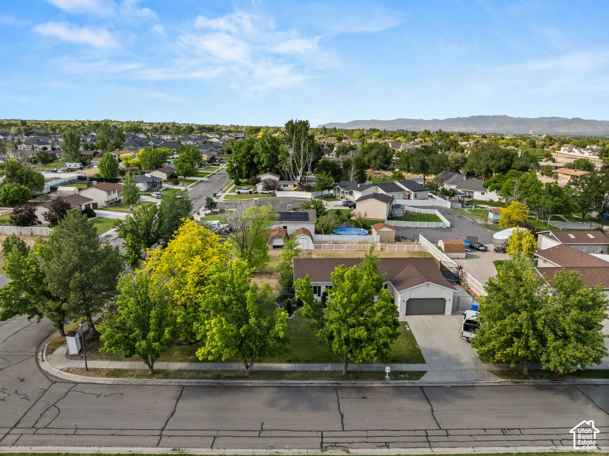 Expansive residential lot featuring mature trees, a two-car garage, and a long driveway