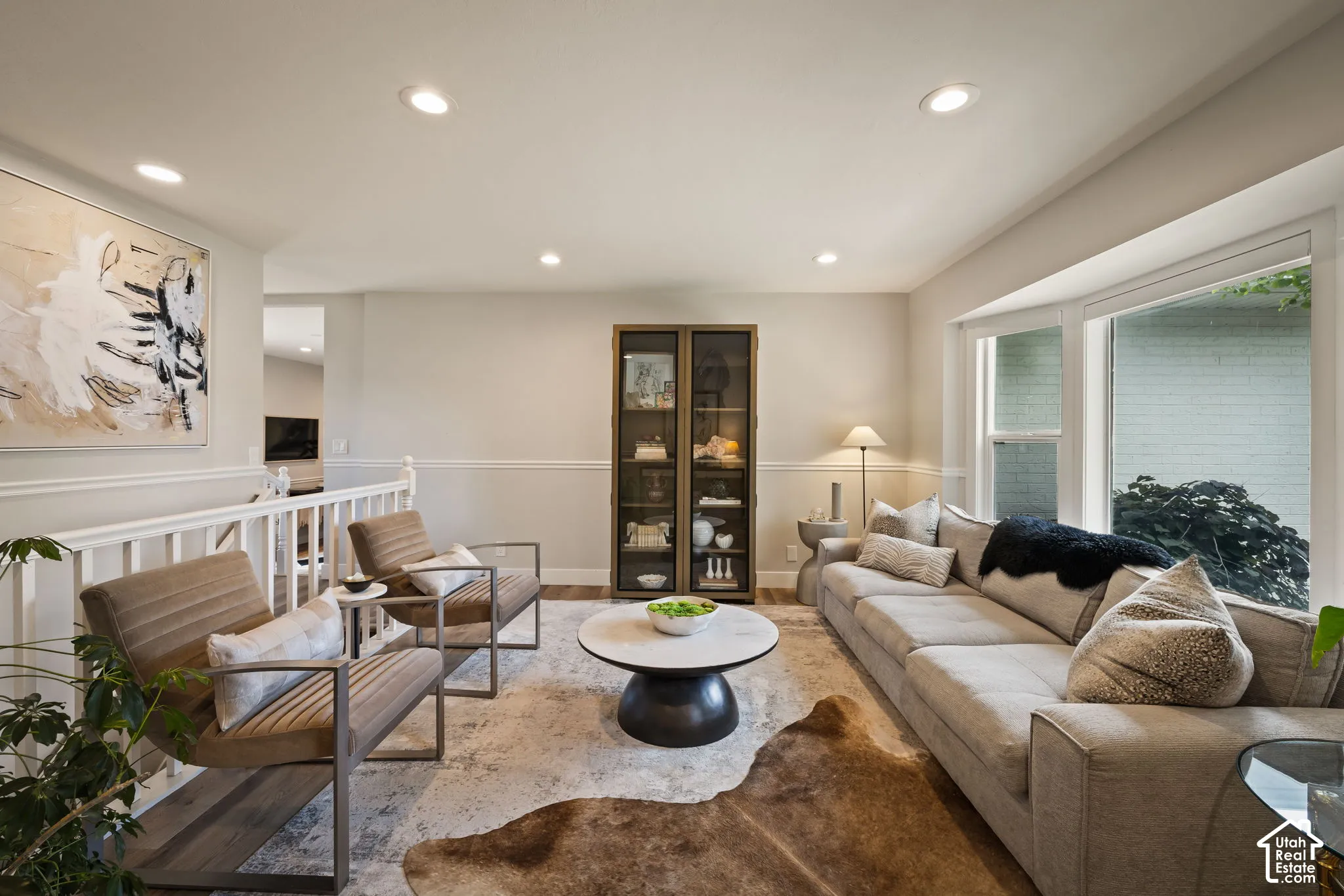 Spacious living area featuring large bay windows, recessed lighting, and crown molding