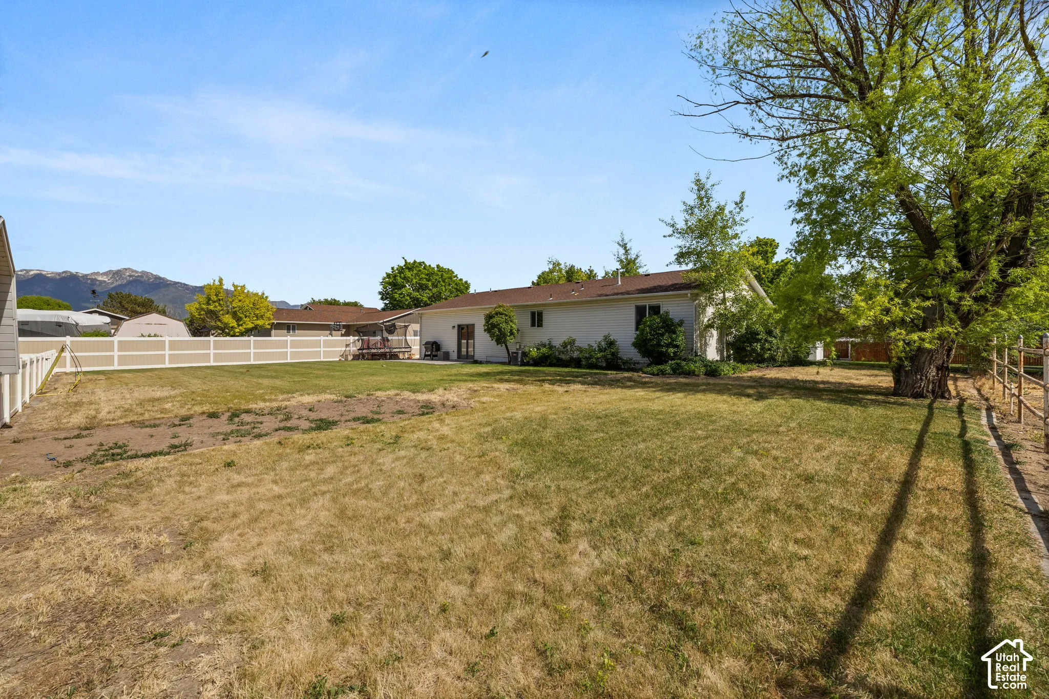 Expansive backyard space featuring a partial privacy fence and mountain backdrop