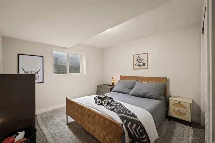 Bedroom featuring a window, light gray walls, white trim, and a patterned area rug