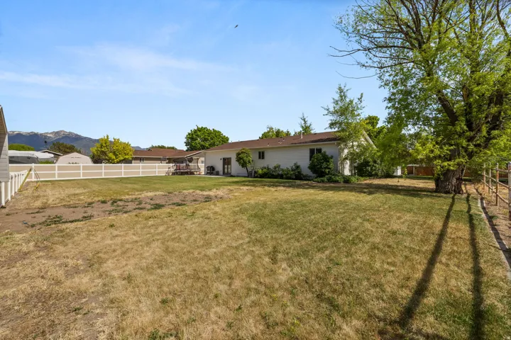 Expansive backyard space featuring a partial privacy fence and mountain backdrop