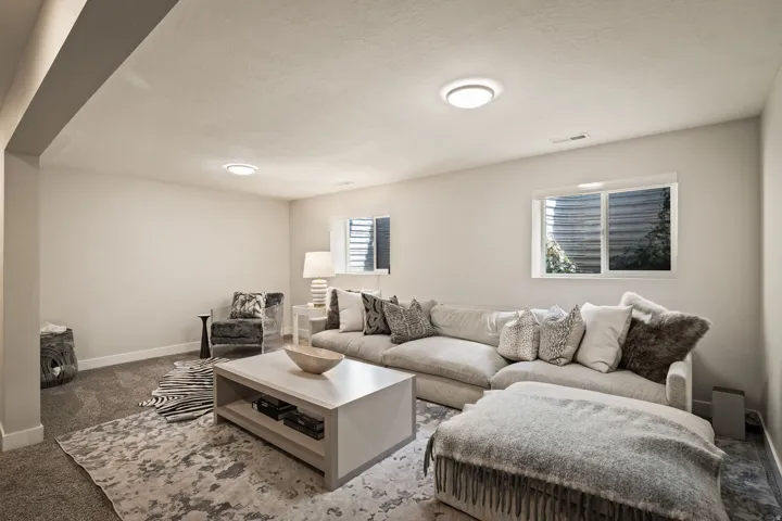 Recessed lighting illuminates this room featuring wall-to-wall carpeting and neutral wall tones