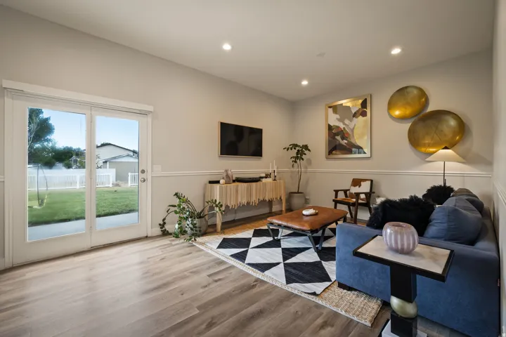 Spacious living area featuring wood-finish flooring, recessed lighting, and a chair rail molding