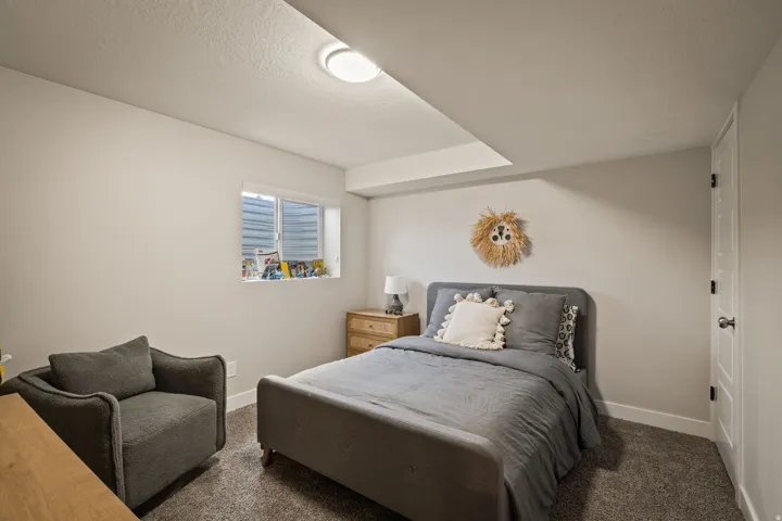 Carpeted room featuring a single window, white trim, and a ceiling light fixture