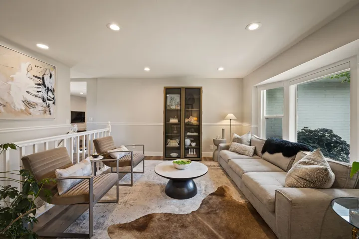 Spacious living area featuring large bay windows, recessed lighting, and crown molding