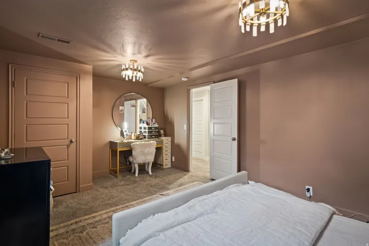 Spacious room featuring neutral-toned walls, plush carpeting, and two modern ceiling light fixtures