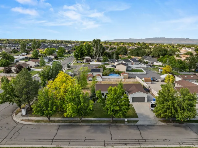 Expansive residential lot featuring mature trees, a two-car garage, and a long driveway