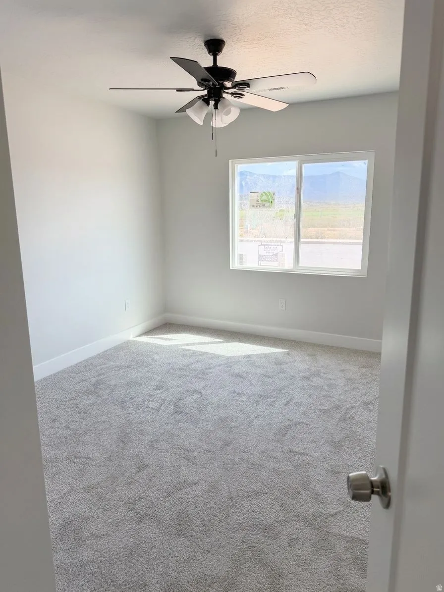 Plush carpet flooring, recessed window, ceiling fan with integrated lighting, white trim